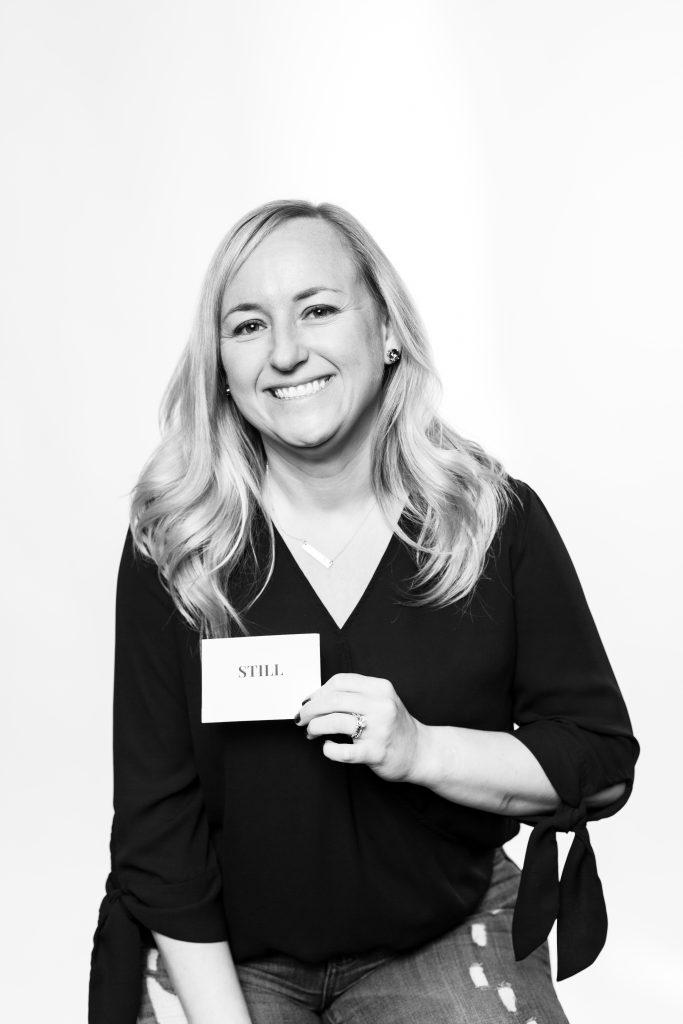 girl in black and white photo holding the word STill